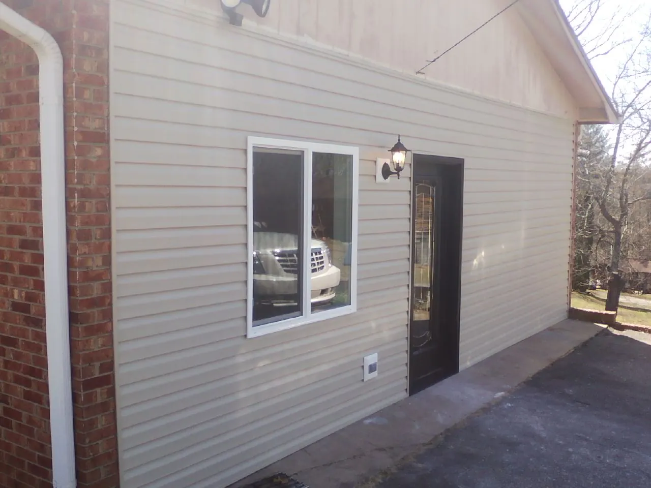 New vinyl siding and entry door on a room addition in Lake City